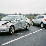 Voiture familiale endommagée mais intacte stationnée au bord de la route, avec un véhicule de remplacement à proximité.
